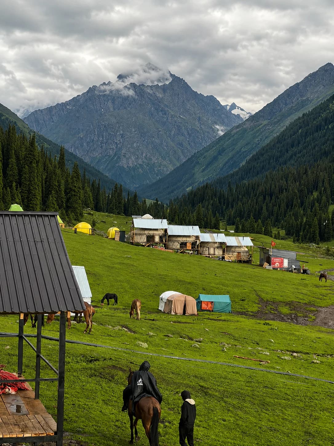 Yurt camp and horses beneath the mountains