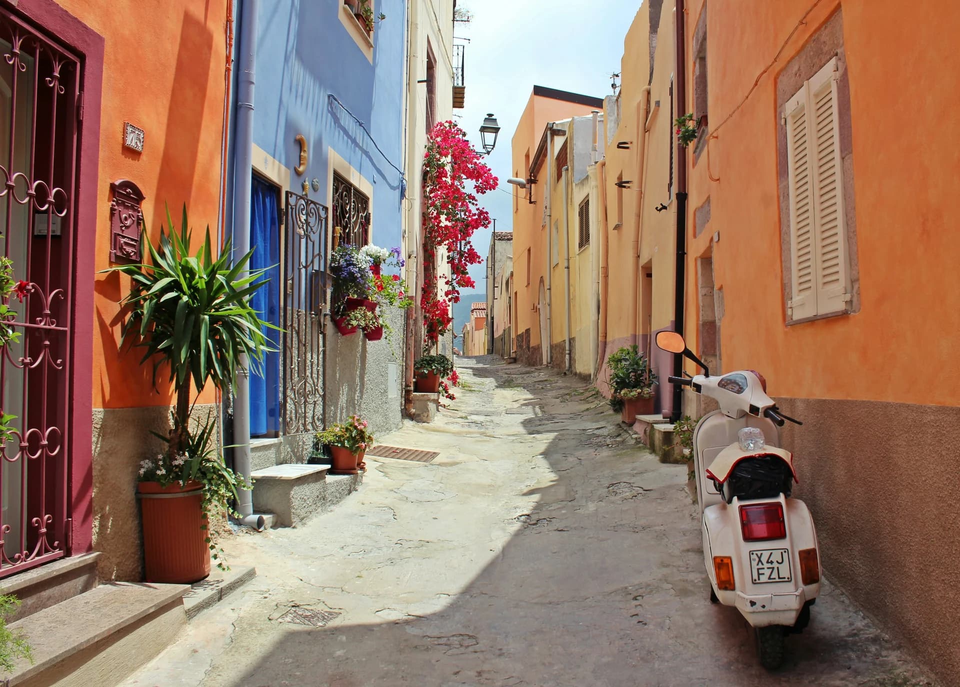 Colorful houses and a vintage scooter on a quiet Italian lane