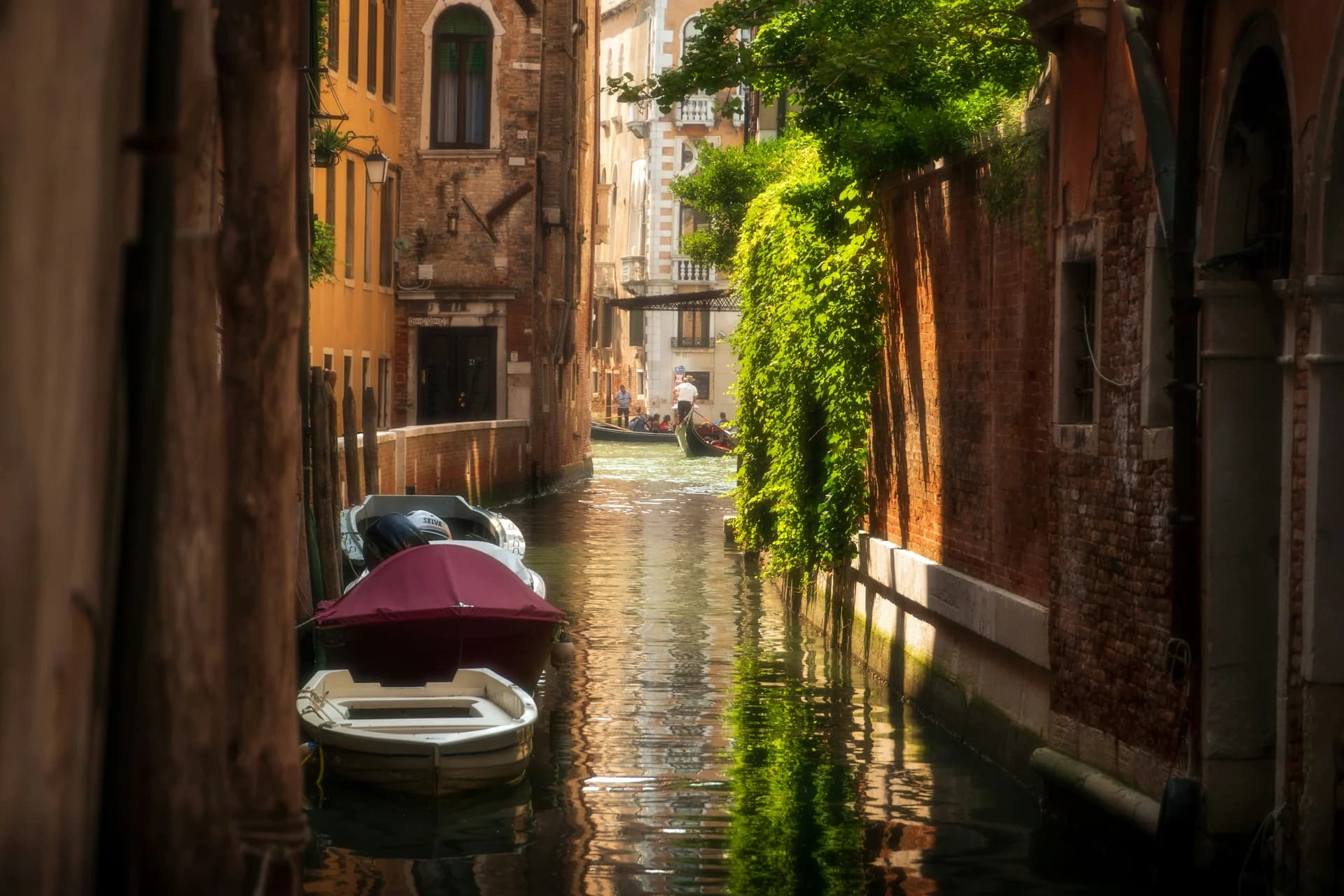 Gondola and boats on a sunlit canal in Venice