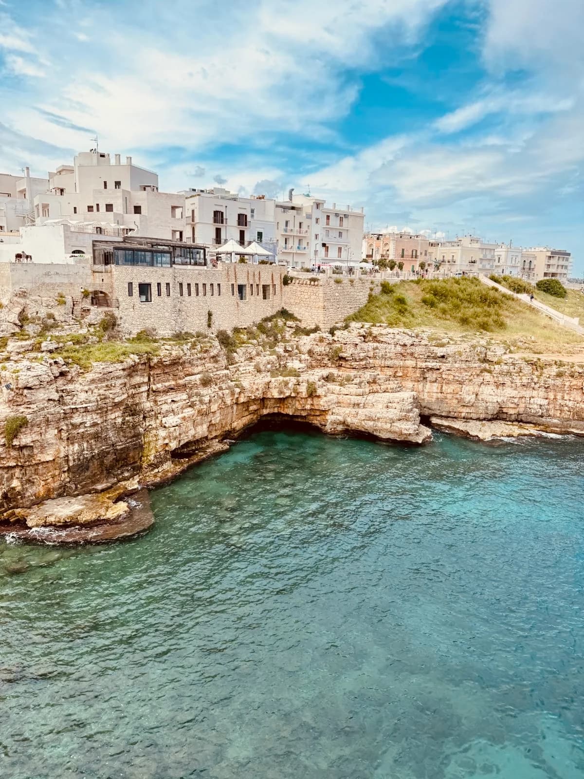 Whitewashed coastal town above clear blue water in Puglia