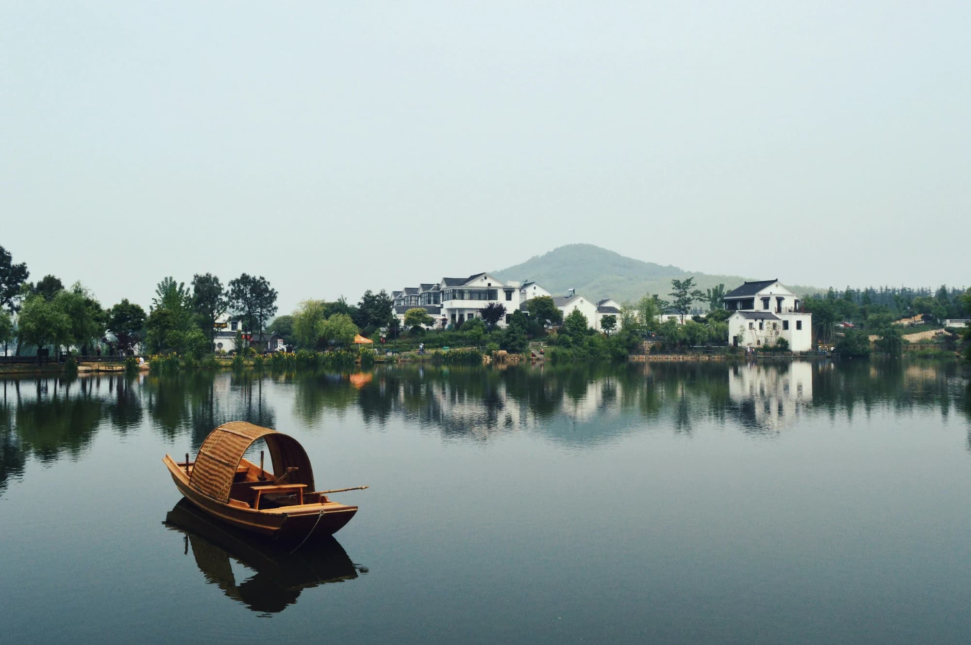 Traditional boat on a lake beside a Chinese waterside village